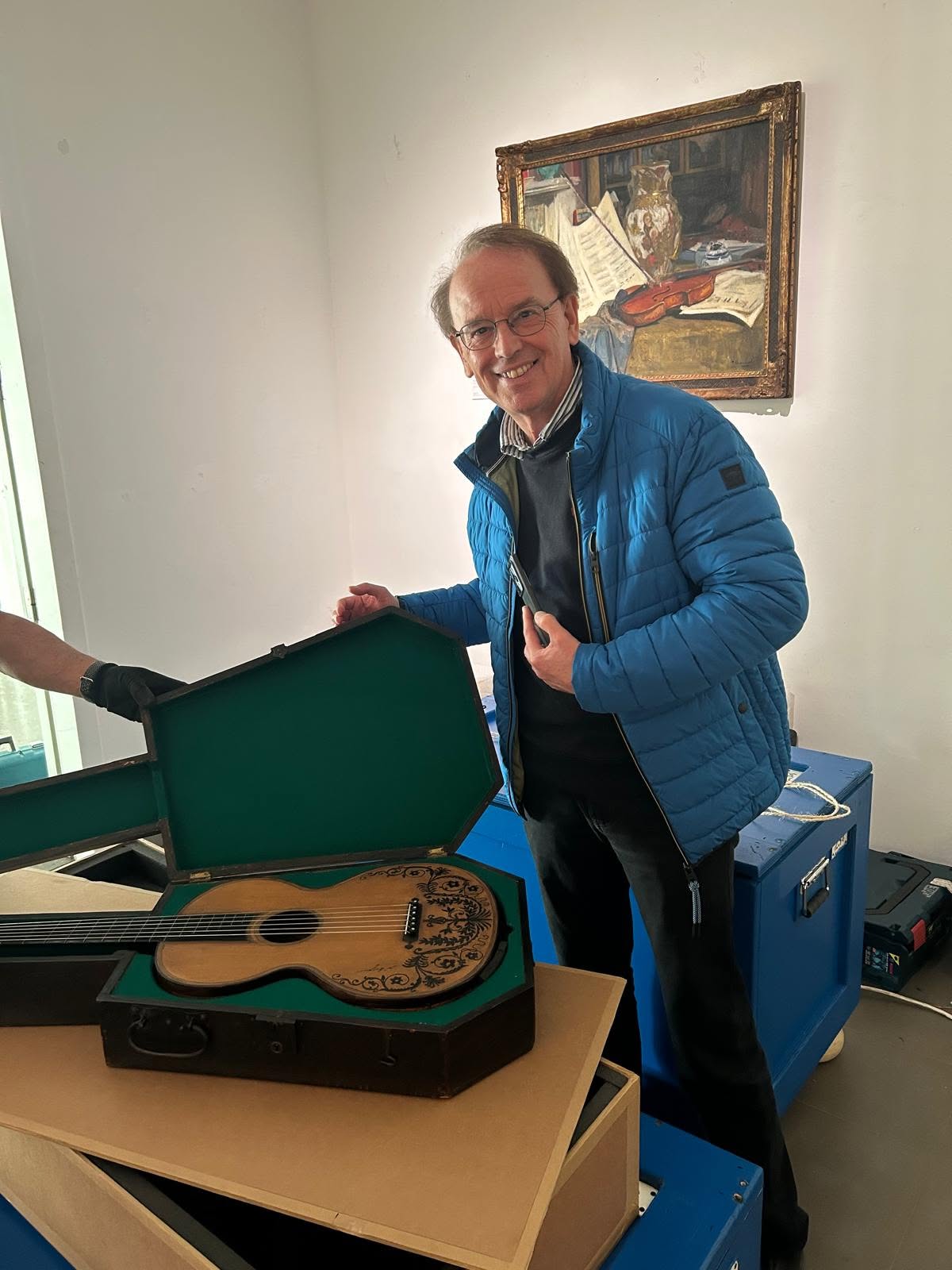 Patrick Dheur auprès de la guitare de Paganini pendant les préparatifs de l’exposition